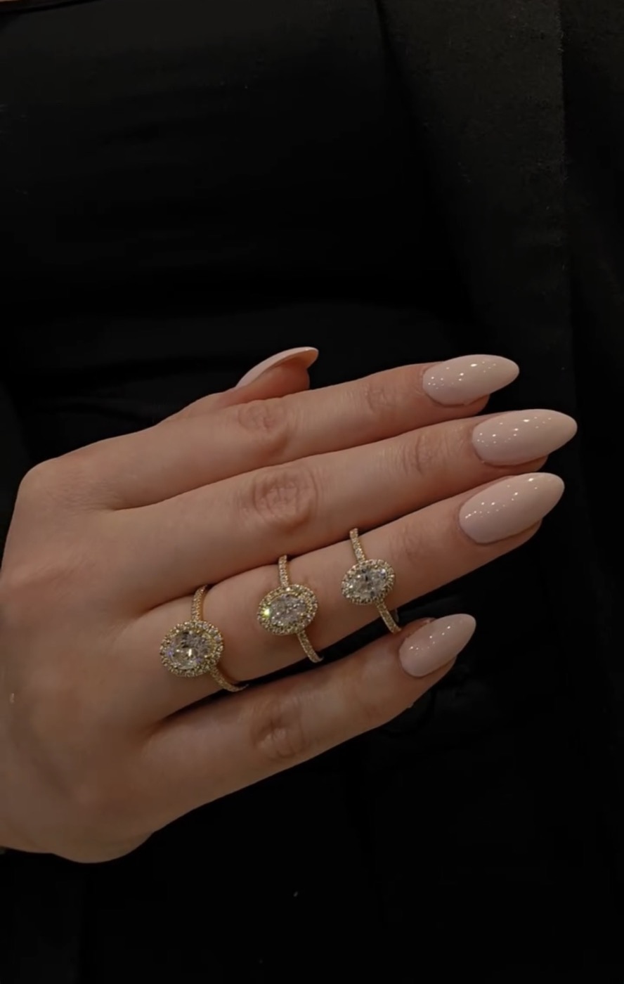 Forlovelsesring i guld med oval diamant og brillanter langs skinnen